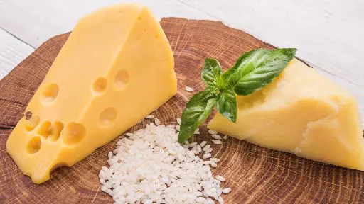 A picture of Baby swiss cheese slices on the wooden tray