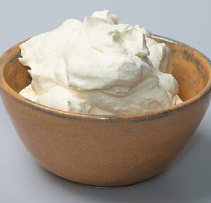 A bowl of whipped cream on top of a table.