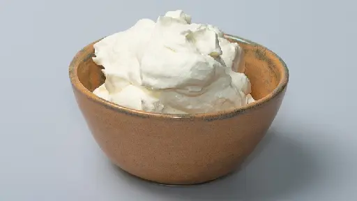 A bowl of whipped cream on top of a table.