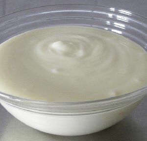 A bowl of yogurt on top of a table.