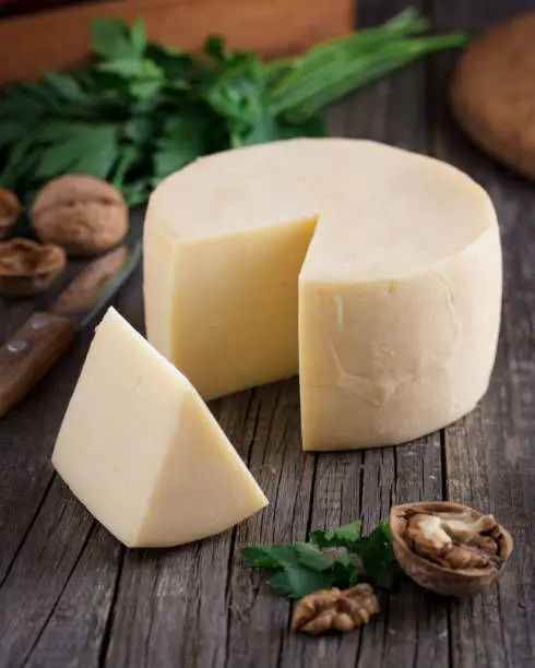 A picture of the cheese and a walnut on the table