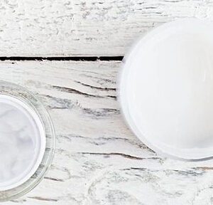 A white table with two cups and one cup of water.